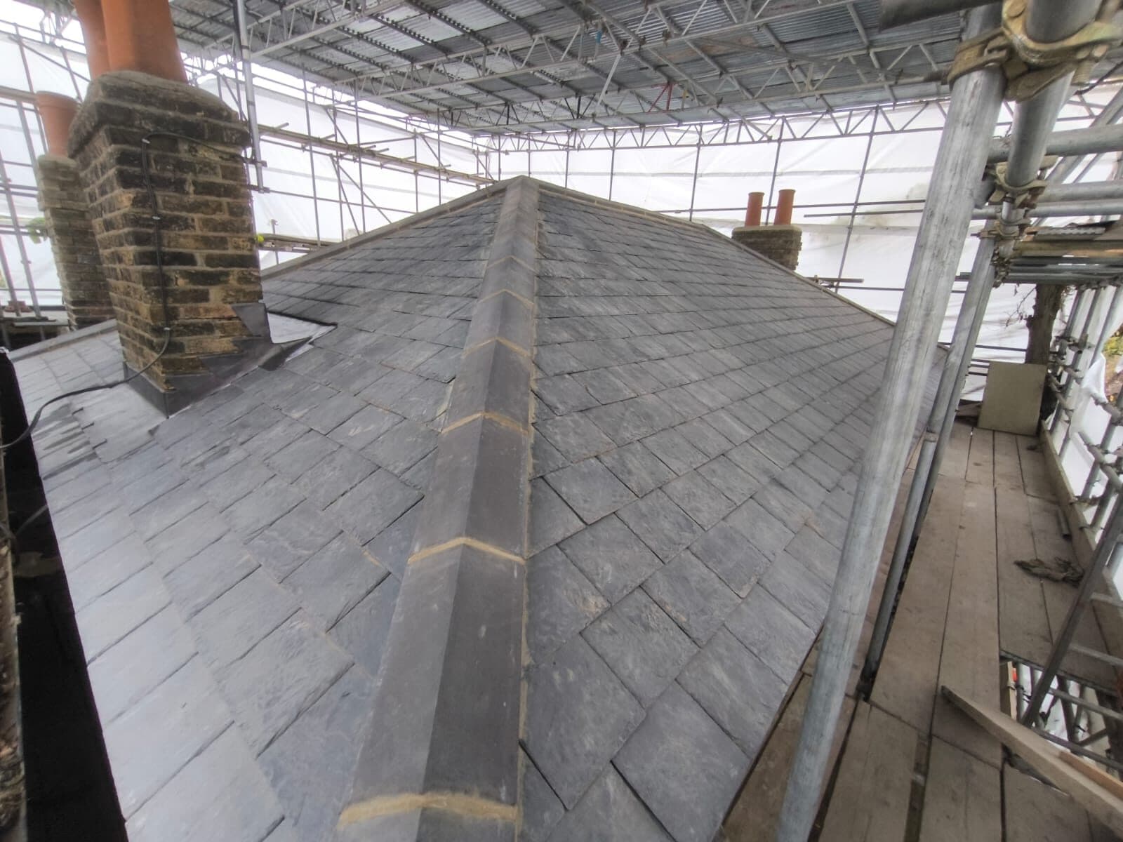 Natural Spanish slate pitched roof with clay ridge tiles