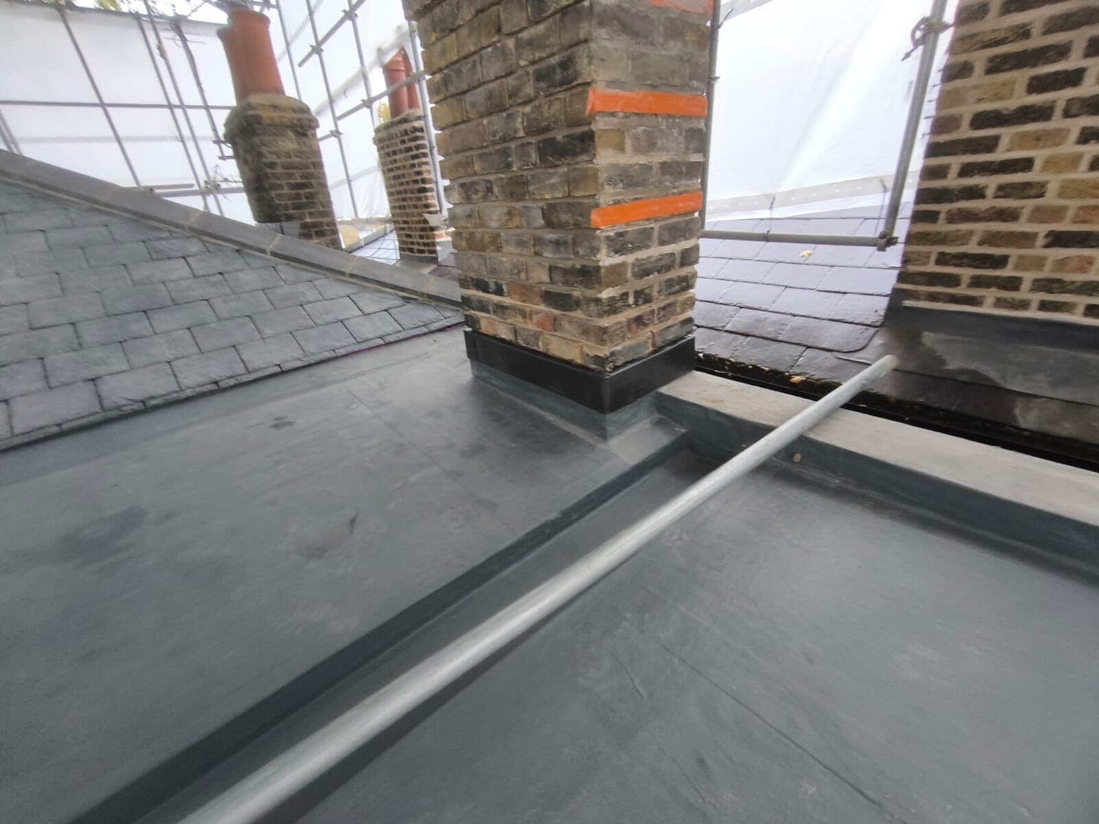 Triflex PMMA waterproofing dressed around a chimney stack